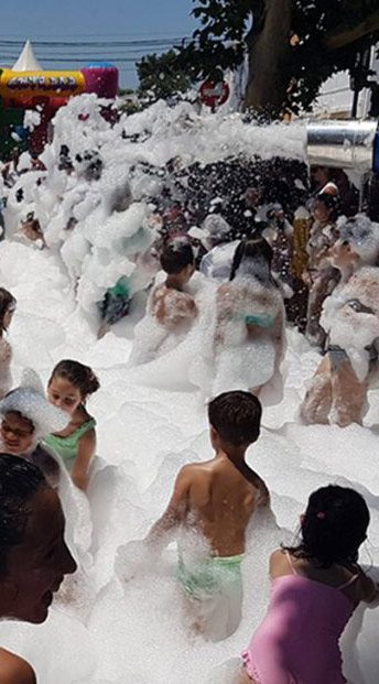 Niños jugando entre la espuma en una fiesta de la espuma – Castillos Hinchables Madrid