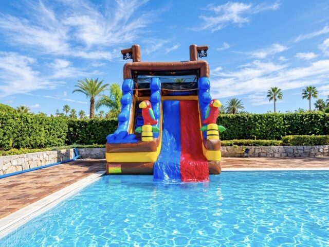 Tobogán acuático hinchable Pirata con loros y barco pirata cayendo a la piscina – Castillos Hinchables Madrid
