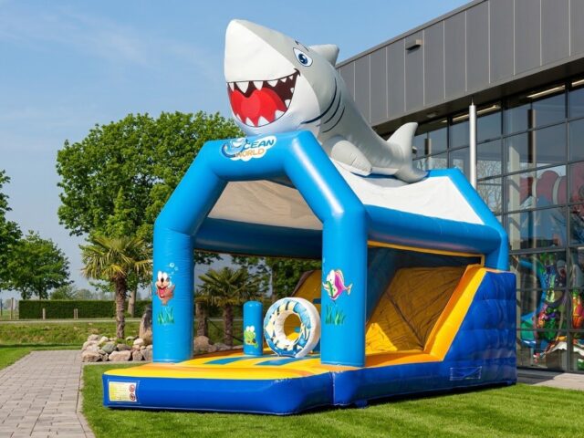 Combo hinchable Tiburón con gran tiburón en el techo, peces de colores, obstáculos y tobogán sobre césped – Castillos Hinchables Madrid
