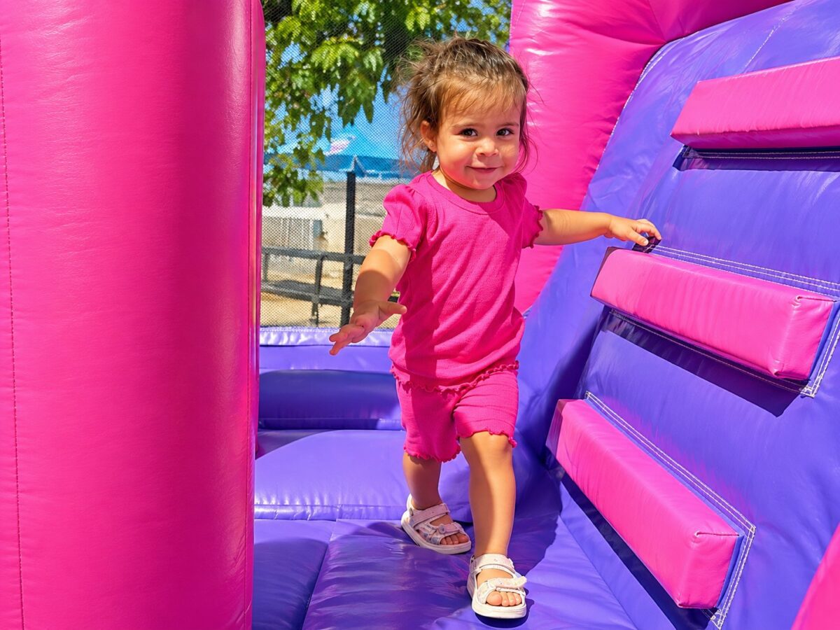 Niña jugando en un castillo hinchable rosa y morado en un cumpleaños – Castillos Hinchables Madrid